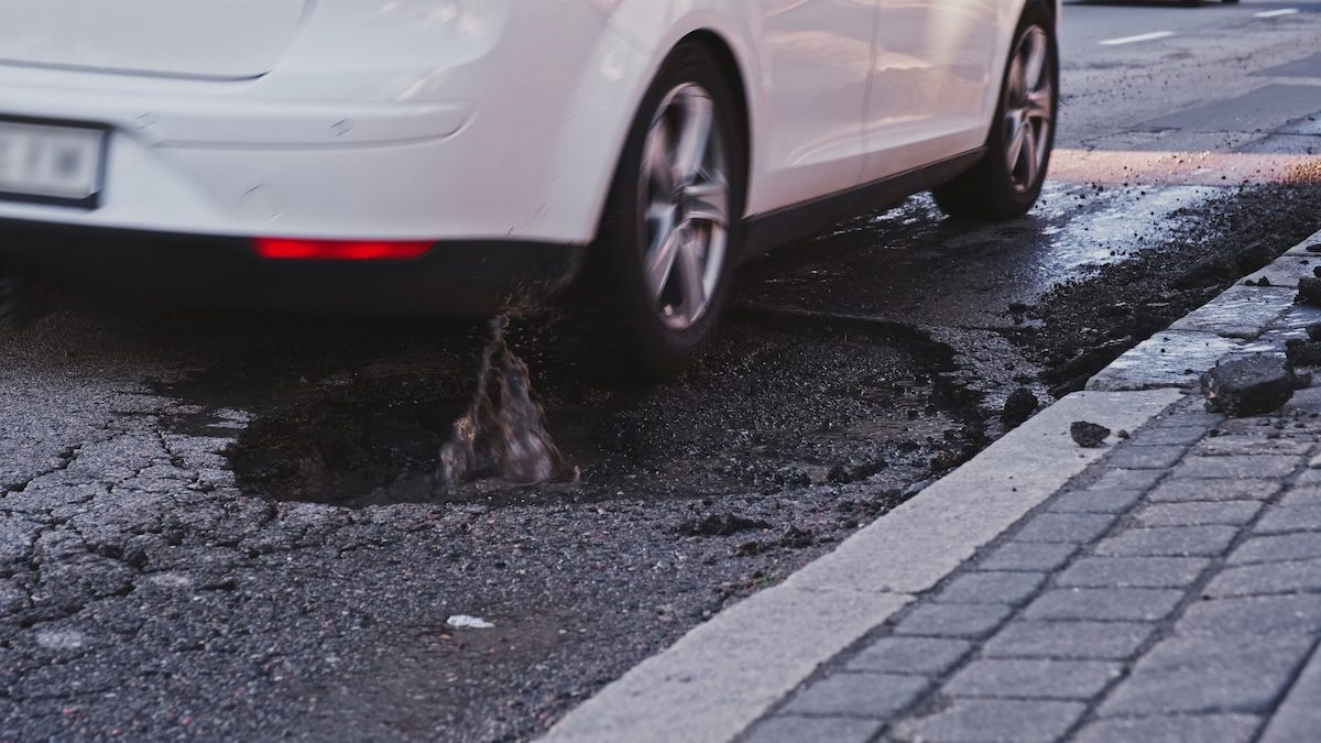 wheels weren't made to take in the force when tyres hit the hard edges of potholes because they will bend or crack vehicles,driving,over,deep,large,erosion,hole,in,city,street