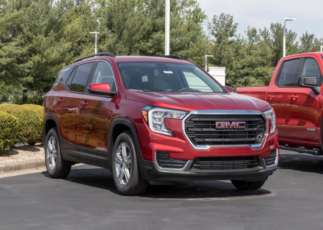 a red gmc terrain in a parking lot.